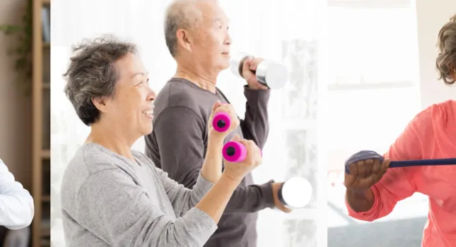 seniors doing yoga, weights, and bands on a ball